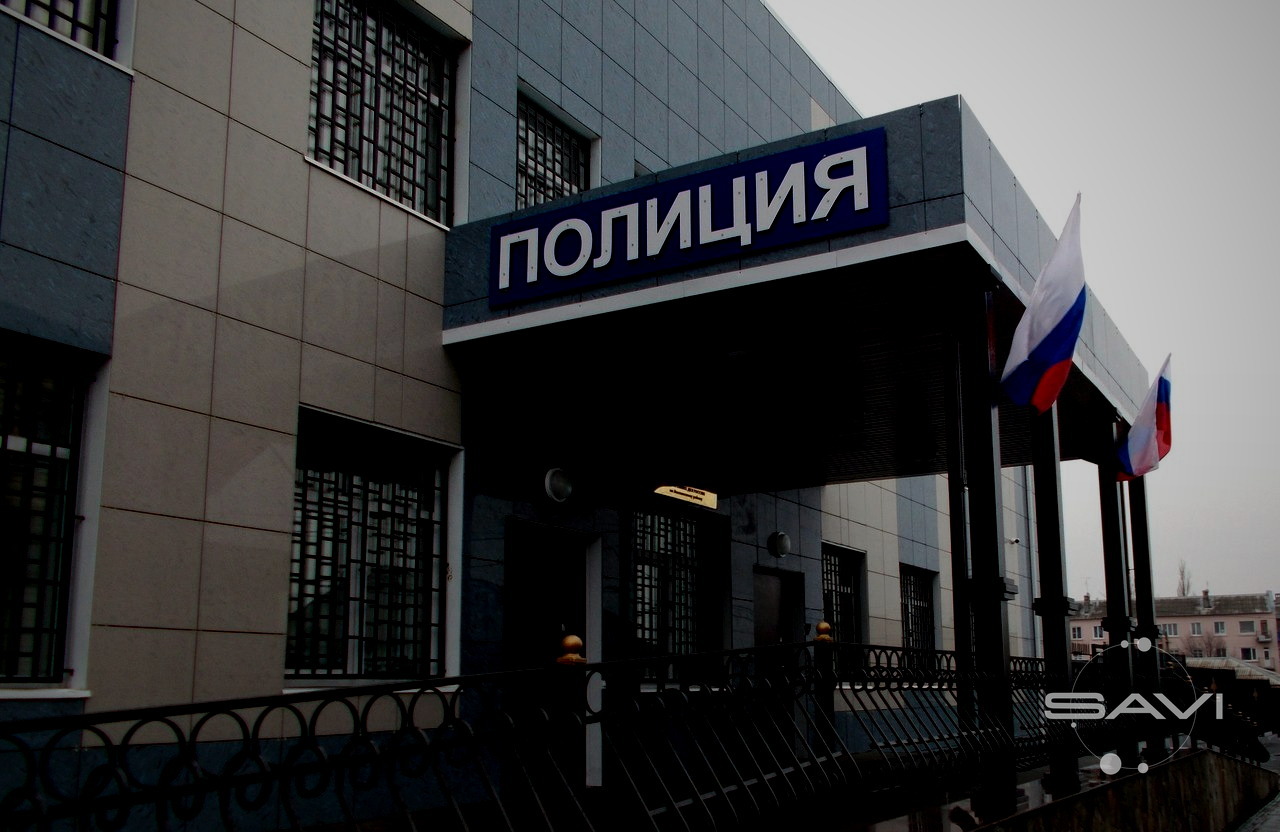 Здание отдела полиции с вывеской ПОЛИЦИЯ и российскими флагами